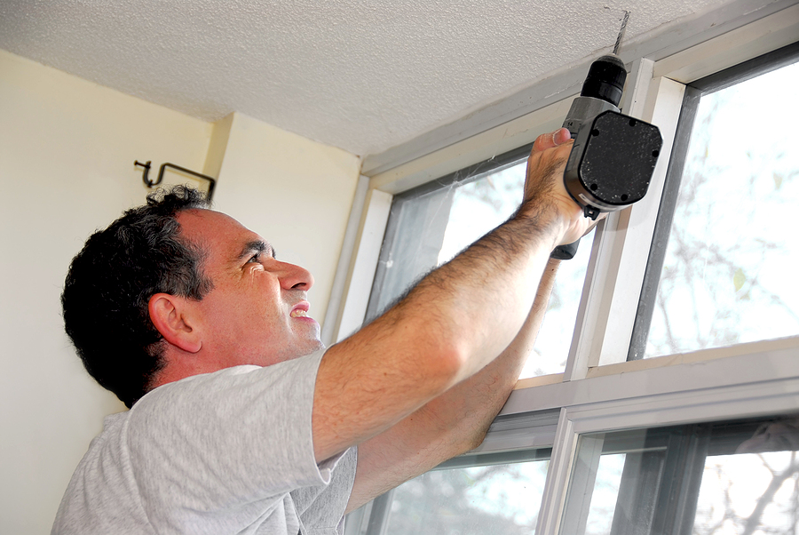 Energy-Efficient Windows, man drilling a hole in a ceiling